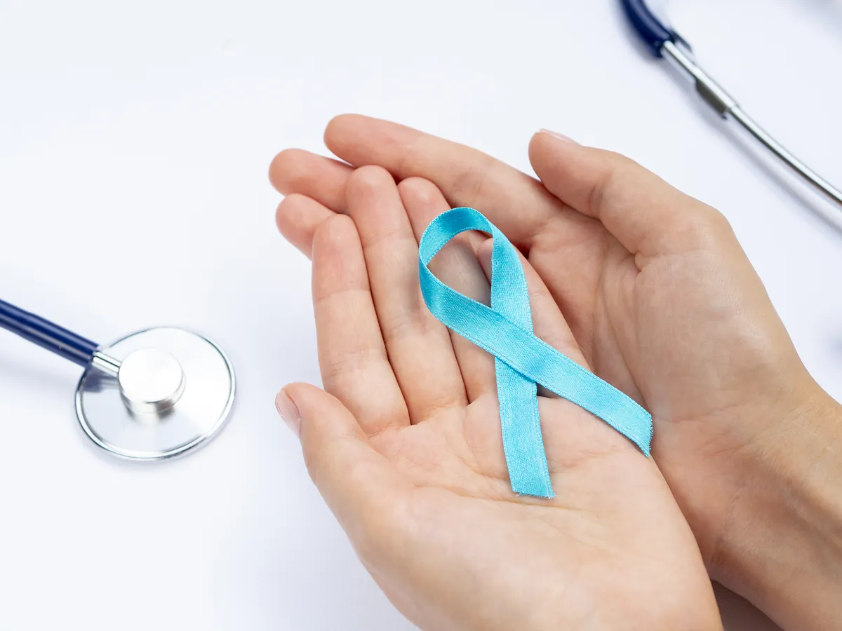 Cancer awareness ribbon held in hands