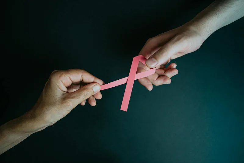 Cancer awareness ribbon held in hands