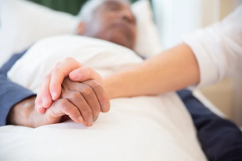 Doctor holding an elderly patient's hand